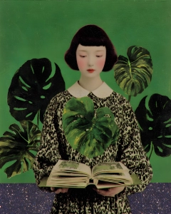 Portrait of a young girl reading an open book, surrounded by large dark green monstera leaves against a green background.