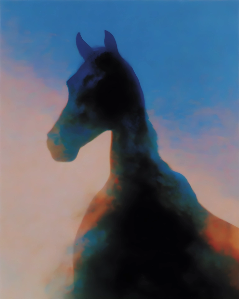 Blurred dark giraffe silhouette against a soft blue sky with peach sunset tones.